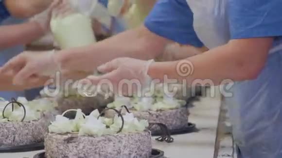 传送带上的蛋糕在蛋糕厂装饰蛋糕的工人在糖果厂忙碌的一天视频的预览图
