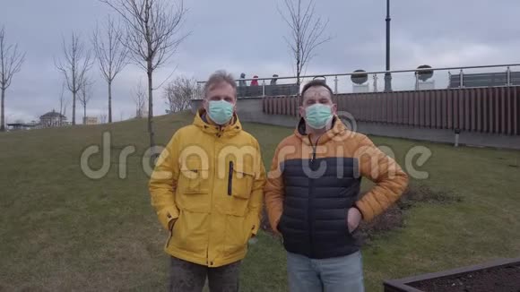 两个戴着医用面具的男人走向摄像机视频的预览图