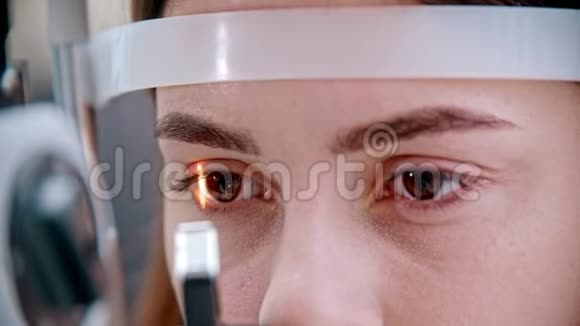 眼科医生明亮的光线集中在美丽的女人的眼睛上视频的预览图