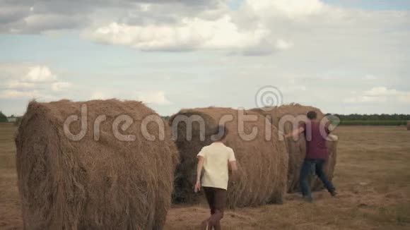那男孩和他父亲在田野里的露天干草堆里玩耍乡村生活儿童教育视频的预览图