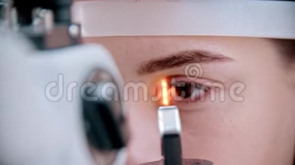 眼科医生明亮的光线聚焦在女人的眼睛上视频的预览图