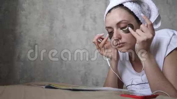 一位年轻的女士在休息日插入耳机并享受音乐化妆品早晨放松视频的预览图