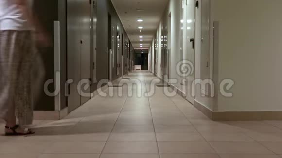 女人独自走在空荡荡的黑暗旅馆走廊里走进房间视频的预览图