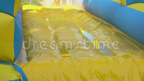 小男孩在水上公园乘黄色泡沫滑梯视频的预览图