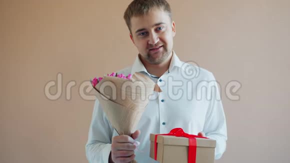 一副帅哥拿着礼品盒和一束鲜花独自微笑的画像视频的预览图