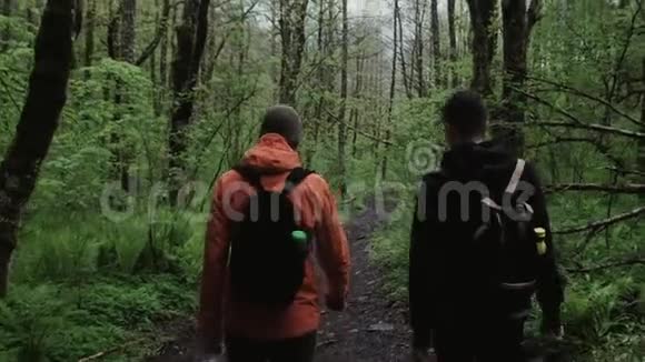 寒冷的天气里两个徒步旅行者在森林的小路上行走视频的预览图
