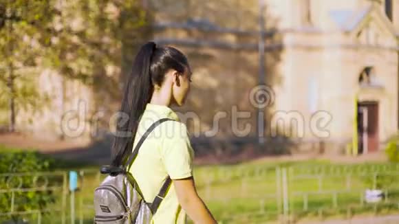 年轻迷人的女孩在公园日落时散步柔和的光线4K视频的预览图