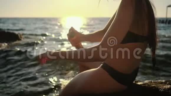女人在沙滩上的皮肤上喷洒防晒霜视频的预览图
