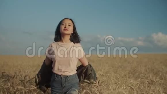 欢乐的亚洲女人在日落时漫步麦田视频的预览图