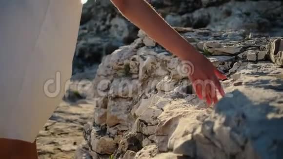 女人用手触摸岩石在夏天漫步在大自然中视频的预览图
