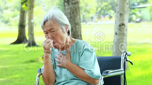 亚裔女儿戴医用口罩为高龄产妇因生病而咳嗽发烧的高龄妇女防止g的传播视频的预览图