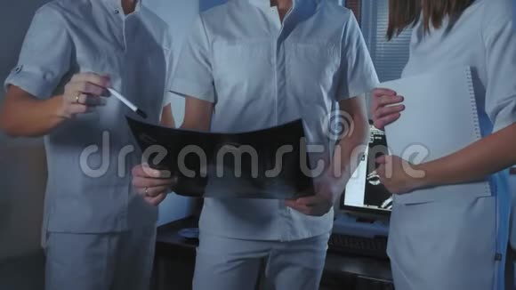 三位医生一起看一张病人的x光照片视频的预览图
