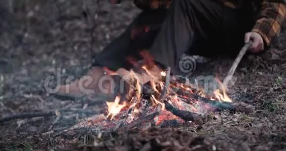 人坐在森林里的火附近视频的预览图