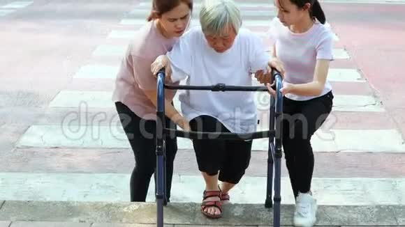 劳累的亚洲老年妇女和步行者在人行横道上过马路后试图爬上人行道面对困难巴里视频的预览图