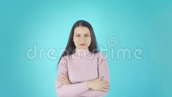 年轻迷茫的女士站在蓝色背景下的镜头视频的预览图