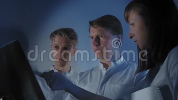 三位医生一起看一张病人的x光照片视频的预览图