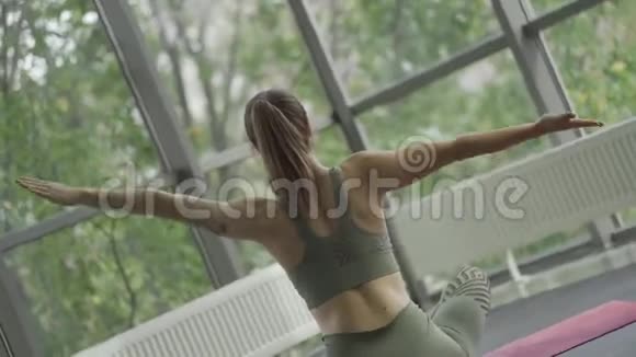 年轻的运动女性练习瑜伽后景旋转摄像机移动视频的预览图
