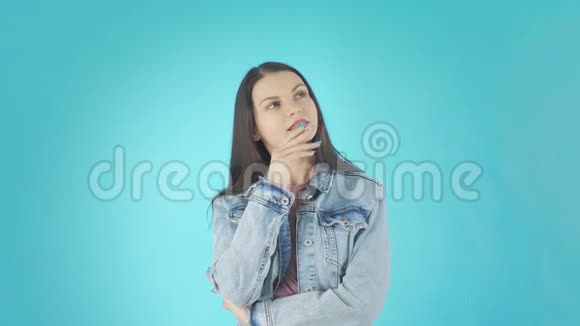 一个年轻体贴的女人穿着牛仔夹克双臂交叉正在思考一些事情视频的预览图