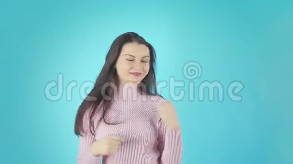 穿着粉色衬衫跳舞的快乐女人看着镜头越过黄色背景视频的预览图