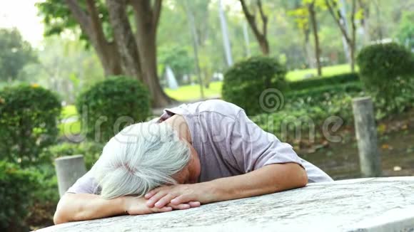 患病的亚洲老妇晕倒在桌旁不省人事面朝下摔倒年老的女病人因心脏衰竭停止呼吸视频的预览图
