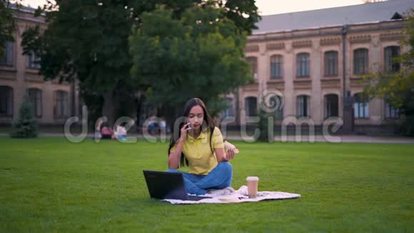 远程工作年轻的拉丁裔黑发女孩在午餐期间用手机开了个会议远程学习自由职业4K视频的预览图