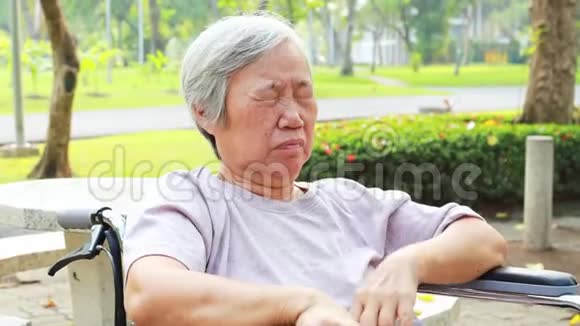 亚洲老年妇女有困倦的表情老年妇女打哈欠用手捂住张开的嘴老人感到打哈欠打瞌睡困倦视频的预览图