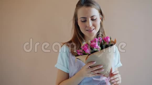 女士捧着玫瑰花闻着玫瑰花看着镜头视频的预览图
