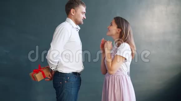 英俊的男朋友送礼物给兴奋的年轻女人亲吻视频的预览图