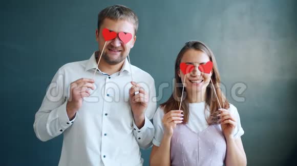 慢动作吸引人男人和女人拿着心形卡片微笑视频的预览图