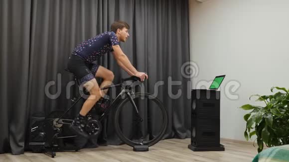 人们在骑智能自行车训练机时喝能量饮料或等渗饮料室内自行车概念男性做有氧运动视频的预览图