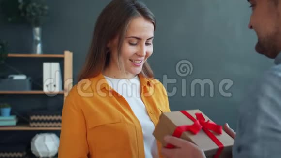 爱的男人祝贺女人送礼物盒拥抱在家表达爱视频的预览图