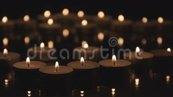 许多电影中的蜡烛在黑暗中燃烧视频的预览图