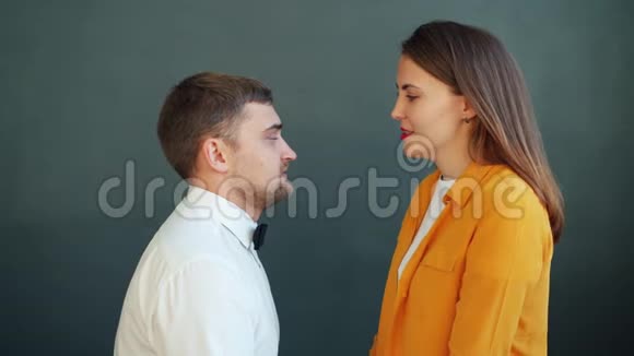 一对夫妇在灰色背景下接吻的肖像女孩在男人身上留下口红痕迹视频的预览图