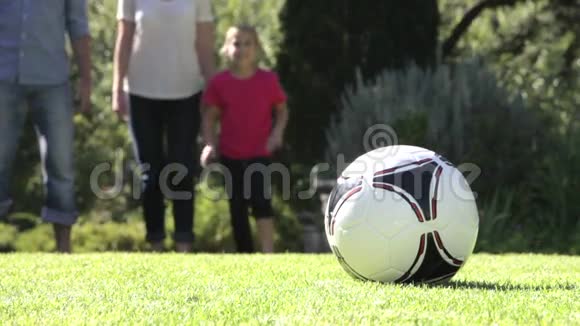 家庭在花园里奔跑踢足球视频的预览图