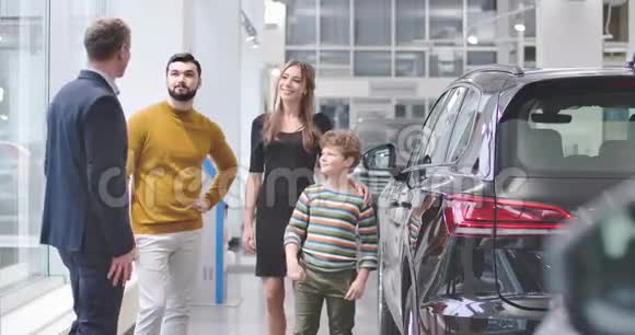 带着红色卷发的白人男孩微笑着示意是的并给了汽车经销商5高购买儿童视频的预览图
