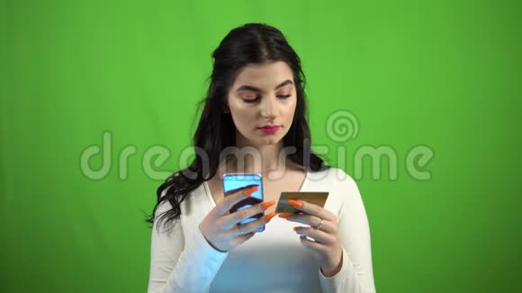 女孩将银行卡号输入智能手机绿屏网上银行视频的预览图