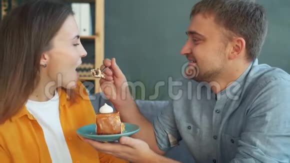 年轻漂亮的女人一边吃蛋糕一边笑一边在家喂她视频的预览图