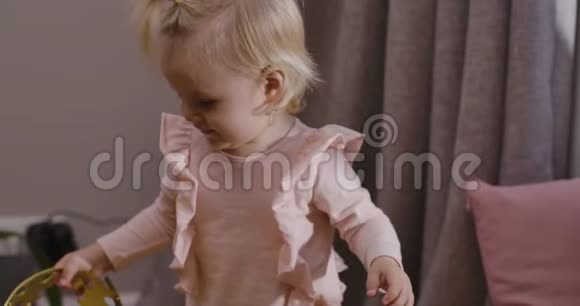 可爱的金发白种人小孩在家玩玩具皇冠穿着粉色上衣在家休息的漂亮女婴视频的预览图