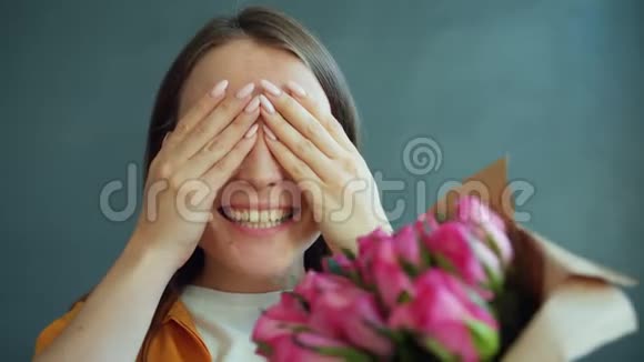 一个闭着眼睛的年轻女人从男人那里得到鲜花感到快乐视频的预览图