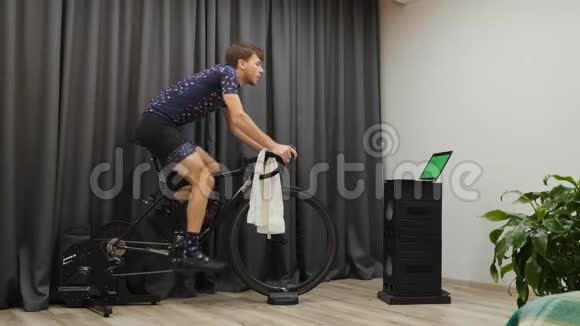 在固定的智能自行车训练器上做减肥运动的人室内自行车概念自信的运动型男性攻势视频的预览图