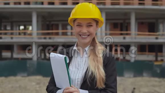 30岁的女工程师穿着西装在建筑背景下打电话视频的预览图