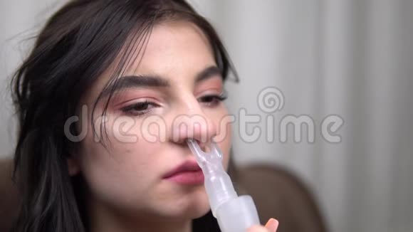 年轻女子通过鼻吸器吸入近距离雾化器行动缓慢视频的预览图
