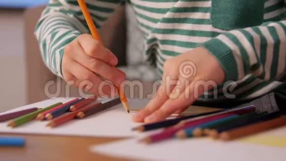 带着彩色铅笔在家画画的小男孩视频的预览图