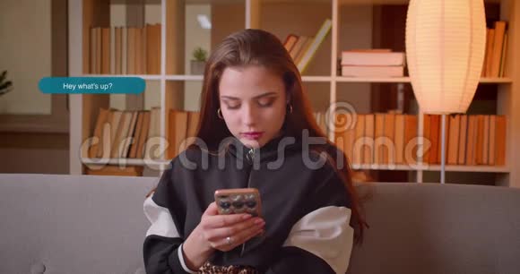 年轻的黑发女性用手机给男朋友发短信的特写照片视频的预览图