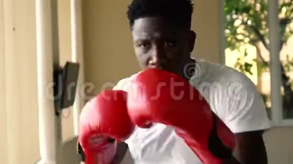 穿着红色拳击手套的非裔美国运动员在运动中攻击在健身房打拳击的男拳击手视频的预览图
