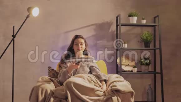 年轻漂亮的女人在家看电视视频的预览图