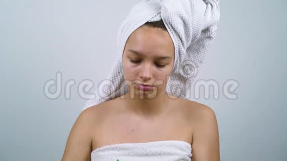 十几岁的女孩裹着浴巾用胶束水清洗脸视频的预览图