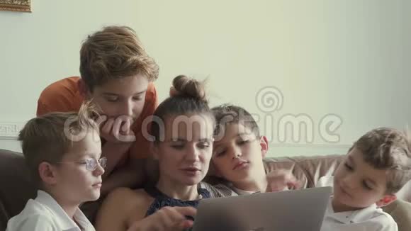 母亲带着四个儿子在家看笔记本电脑电影视频的预览图