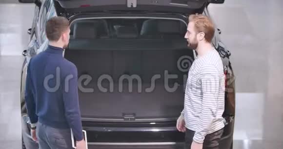 两名白人男子站在卡车前握手的后视图交易者和客户进行交易视频的预览图