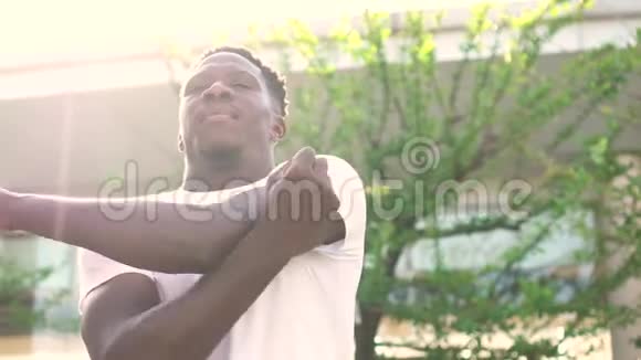 非裔美国人在城市街道上伸展手臂年轻的男性健身者早上热身视频的预览图